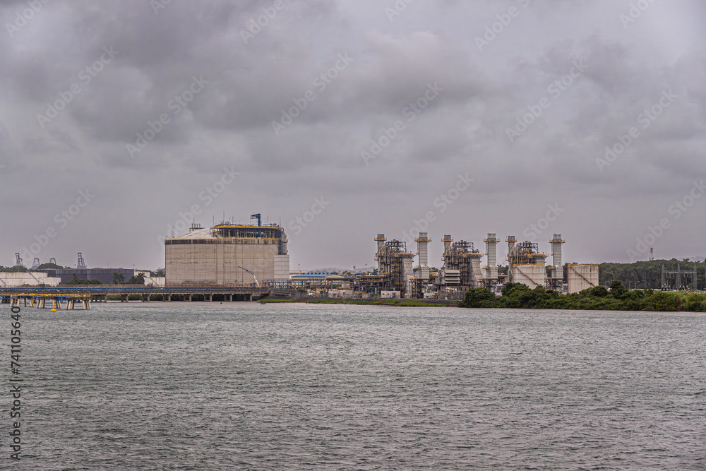 Port of Colon, Panama - July 24, 2023: AES Colon power station or Termoelectrica, heavy industry, buildings and installations to turn coal and gas into heat and electricity under gray cloudscape