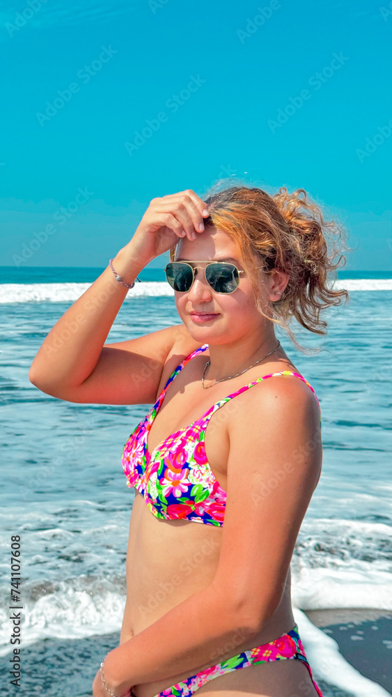 Beautiful young woman in a pink bikini and sunglasses on the beach at sunny day. portrait Beautiful young woman in a pink bikini and sunglasses on the beach at sunny day. portrait