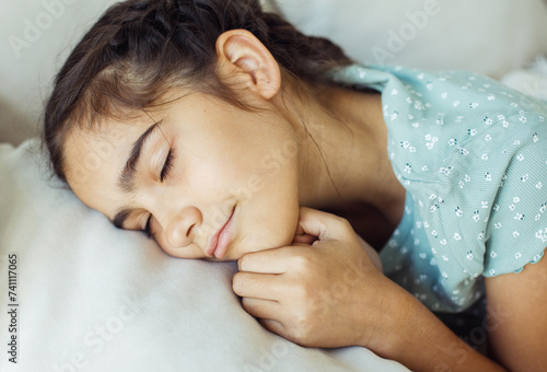 Ten year old girl with pigtails sleeping on the sofa