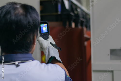 Professional Electrician use thermal infrared camera or thermometer scanning electrical system for preventive maintenance,Industrial thermography,Thermal image of power electric. photo