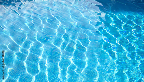 Beautiful blue texture of water. The waves shimmer in the sun. Relax by the pool in summer