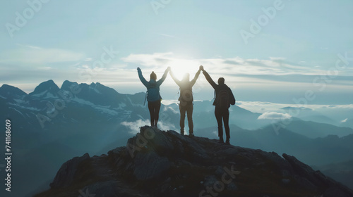 A silhouette hiker three person standing holding hands on top of mountain. Landscape photography.