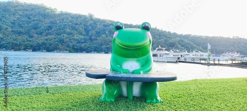 The  green frog statue placed on the  railing of bridge to pavilion at Ita Thao Pier , Sun Moon Lake in Yuchi Township, Nantou County, Taiwan. photo