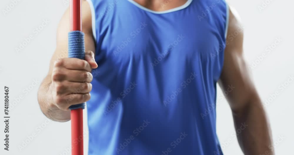 Young biracial athlete man holding a javelin on a white background Young biracial athlete man holding a javelin on a white background