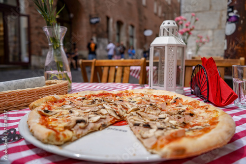 close up large Regina pizza on arestaurant terrace table