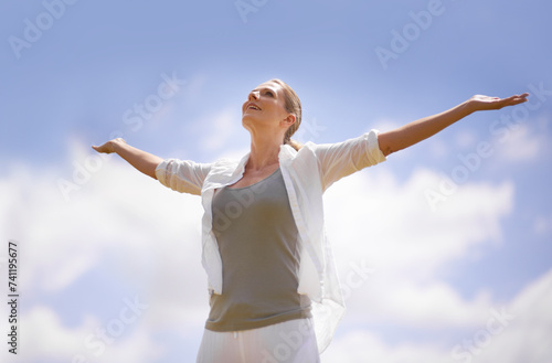 Happy woman, meditation and freedom with blue sky background for spiritual wellness, faith or hope in nature. Calm female person with smile and open arms for fresh air, health and outdoor wellness