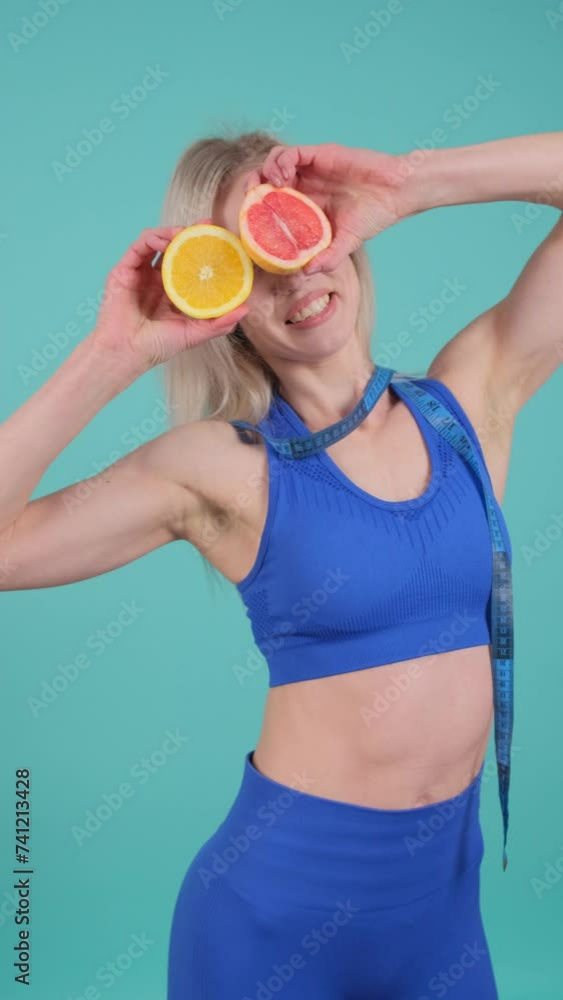 A woman is holding slices of orange in front of her eyes A woman is holding slices of orange in front of her eyes