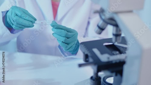 Female scientist prepare sample test by drop on microscope slides for microscopy on cells and bacteria in laboratory for research on pharmacy medical for protect disease and virus
