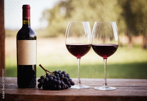 Two glasses for wine on wooden table. Blurred red wine bottle