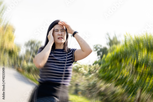 Dizzy woman suffering from vertigo,sensation of whirling,spinning around,loss of balance,she walked with stagger,vertigo while walking outdoor,symptom of giddiness,dizziness attack,health care concept photo