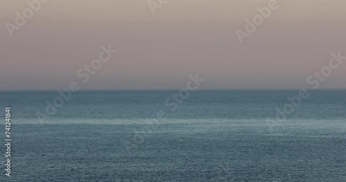 Tranquil scene capturing the sunrise, blending the sea seamlessly with the sky on the distant horizon. photo