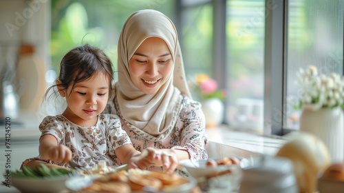 Smilling mom wear hijab and child enjoy love relation cudding hobby moment in kitchen sunday morning at home.