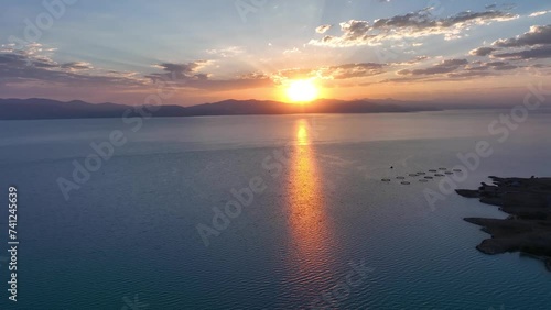 Scenic sunset or sunrise over Sevan lake popular holiday destination in Armenia, Caucasus, West Asia. Daytime of moving white, grey clouds over lake Sevan on background hills photo