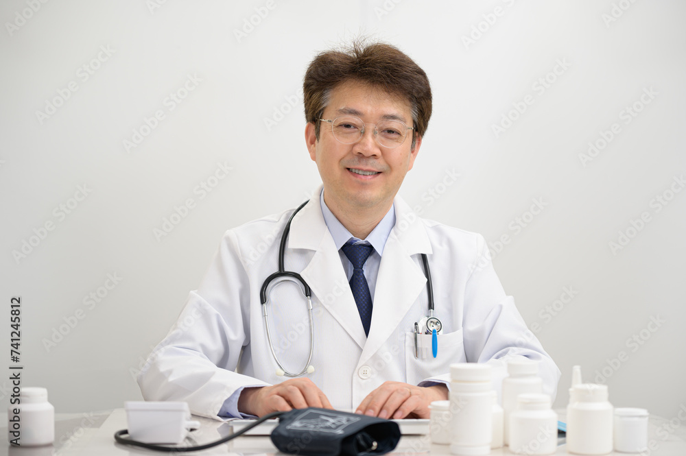 비대면진료를 하고있는 중년의 아시아인 의사 비대면진료를 하고있는 중년의 아시아인 의사