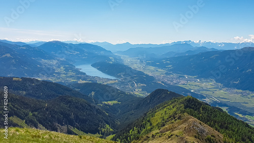 Idyllic hiking trail on alpine meadow with scenic view of lake Millstatt seen from mountain peak Boese Nase in Ankogel Group, Carinthia, Austria. Remote landscape in majestic Austrian Alps in summer