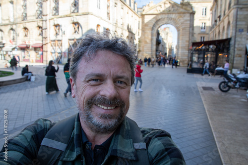 man middle aged smiling outside tour tourist in selphie smartphone picture portrait by telephone photo