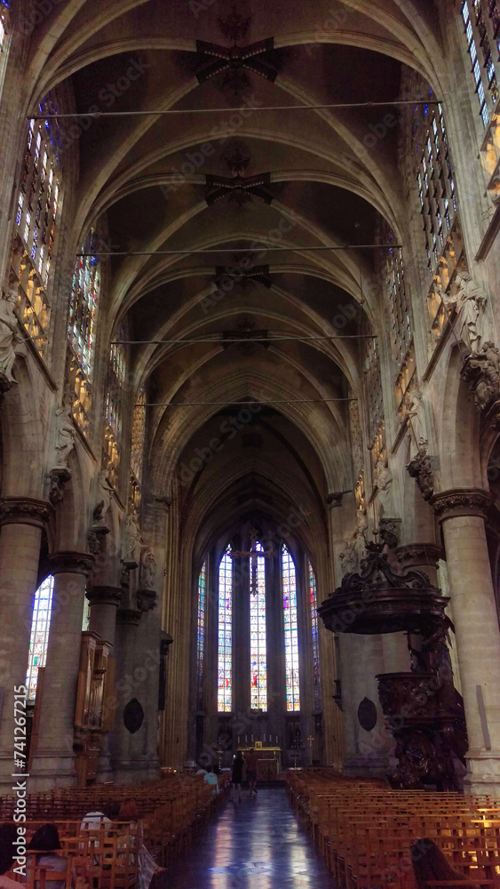 Gothic church interior with vaulted ceilings and stained glass windows.