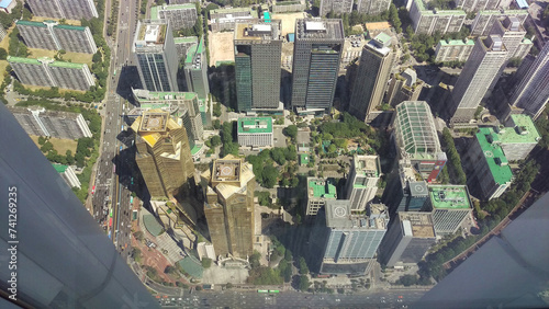 High-angle shot of a dense urban area with skyscrapers and green spaces.