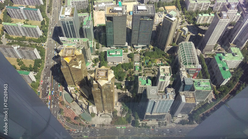 High-angle shot of a dense urban area with skyscrapers and green spaces.