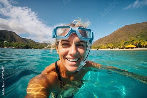 Portrait of happy young woman in snorkeling mask swimming in tropical sea