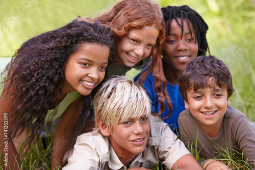 Friends, smile and group of children in field together for summer camp, adventure or outdoor fun. Diversity, grass and nature with happy young kids in park for bonding, leisure or recreation