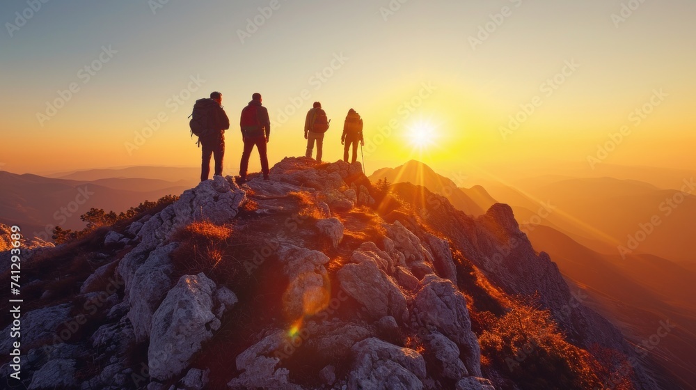 Group of Hikers Standing on Mountain Peak at Sunrise Celebrating Team Success