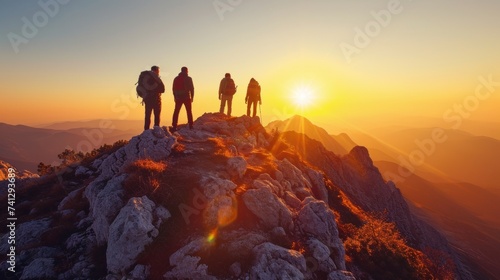 Group of Hikers Standing on Mountain Peak at Sunrise Celebrating Team Success © photolas