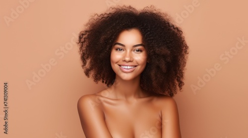 Close-up Portrait of a beautiful African American woman with perfect fresh clean skin on a beige background. Makeup, Cosmetics, youth, skin care, Spa concepts.