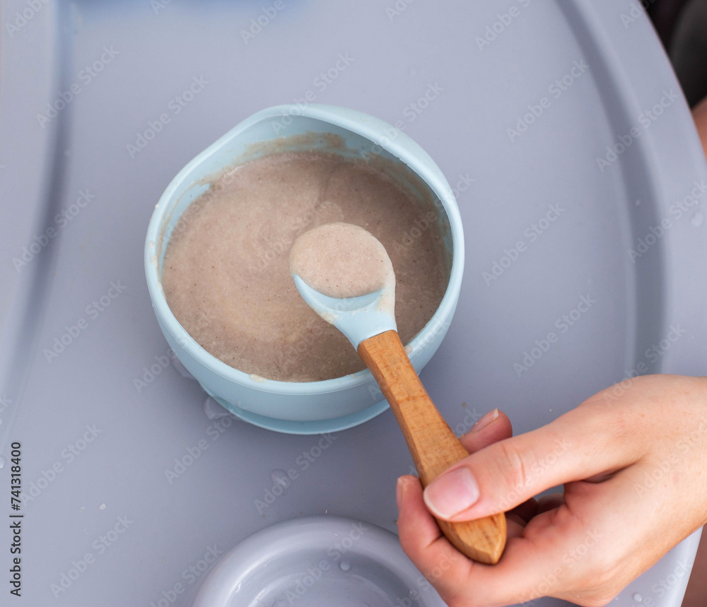 Buckwheat porridge for children in a plate. Feeding children healthy porridge, close-up Buckwheat porridge for children in a plate. Feeding children healthy porridge, close-up