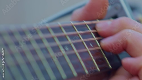 Guitarist plays guitar, super ultra closeup view of hand wrist, fingers, frets and strings