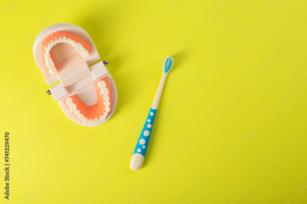 Children's toothbrush with soft bristles on a yellow background next to ...