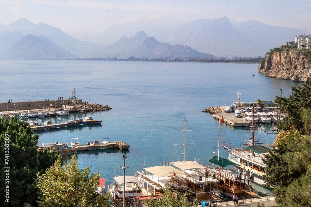 Antalya, Turkey - November 15, 2022: Scenic harbor view with boats with mountains and clear blue sea