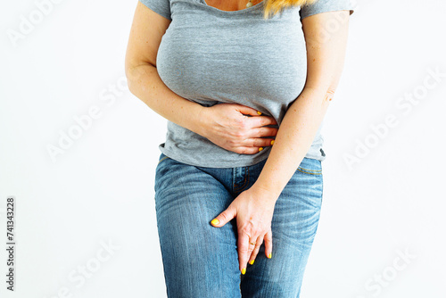 Gynecologic problems, urinary incontinence, female health. Woman holds hands between her legs photo