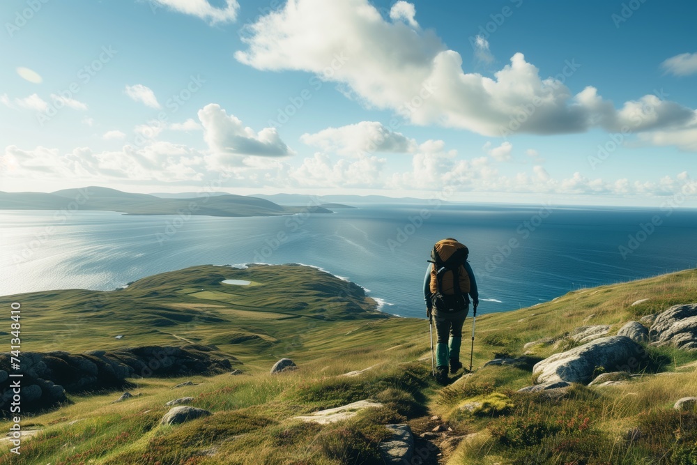 hiker on elevation, expansive sea and coastline in view