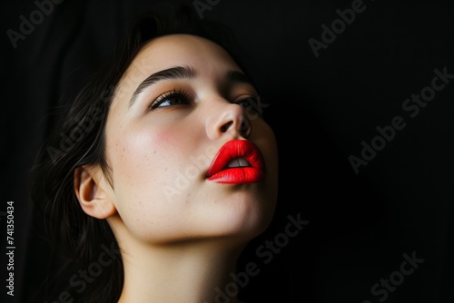 closeup of a woman with red lips against a black backdrop