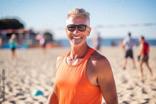 Portrait of senior man playing beach volleyball on a sunny day.