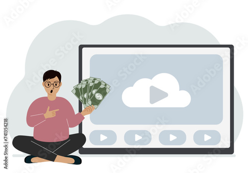 A man holds paper banknotes in his hand, next to a computer with a video. Freelancer, earning money, working on the Internet, training, coaching, business, remote work. photo