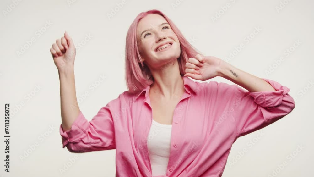 Joyful Woman with Pink Hair Dancing Against White Background Joyful Woman with Pink Hair Dancing Against White Background