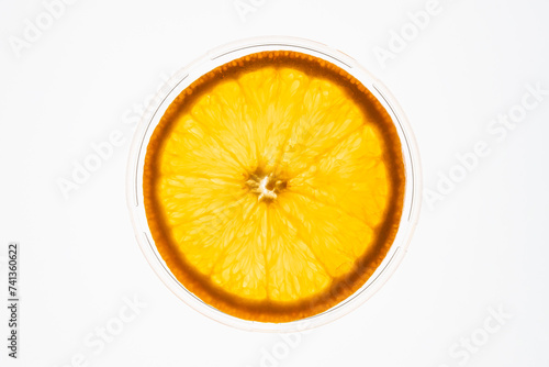 Slice of an orange isolated on white background back lit. Fruit concept