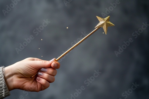 fingertips balancing a wand with a starshaped tip photo