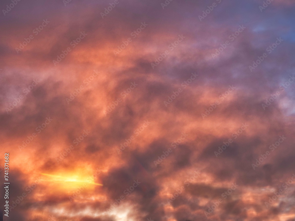 Colorful sunset sky with dark and light color tone and rich orange red color. Nature background. Dramatic cloudscape.