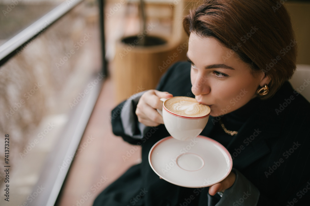 Young woman enjoying coffee in a cozy coffee shop. Young woman enjoying coffee in a cozy coffee shop.