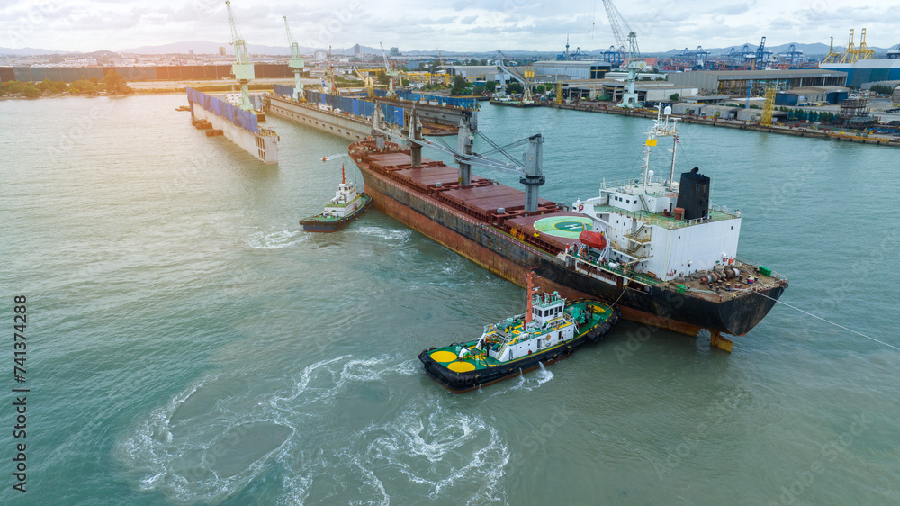 Tug boat pulling cargo container ship to dry dock concept maintenance ...
