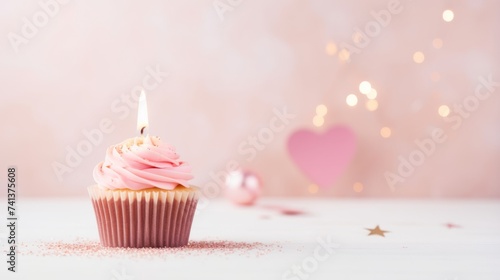 Birthday cupcake with one candle  a heart and a pink background