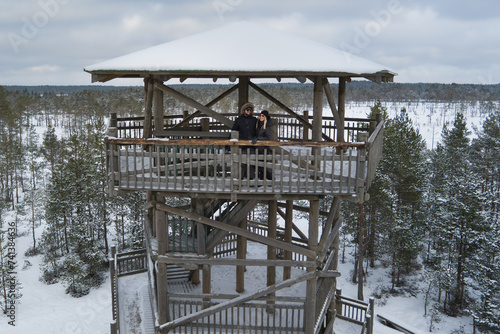 Young couplein winter on an observation tower on the Viru swamp. Drone photo. photo