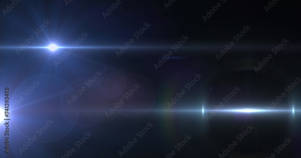 Image of spotlight with lens flare and light beams moving over dark background Image of spotlight with lens flare and light beams moving over dark background