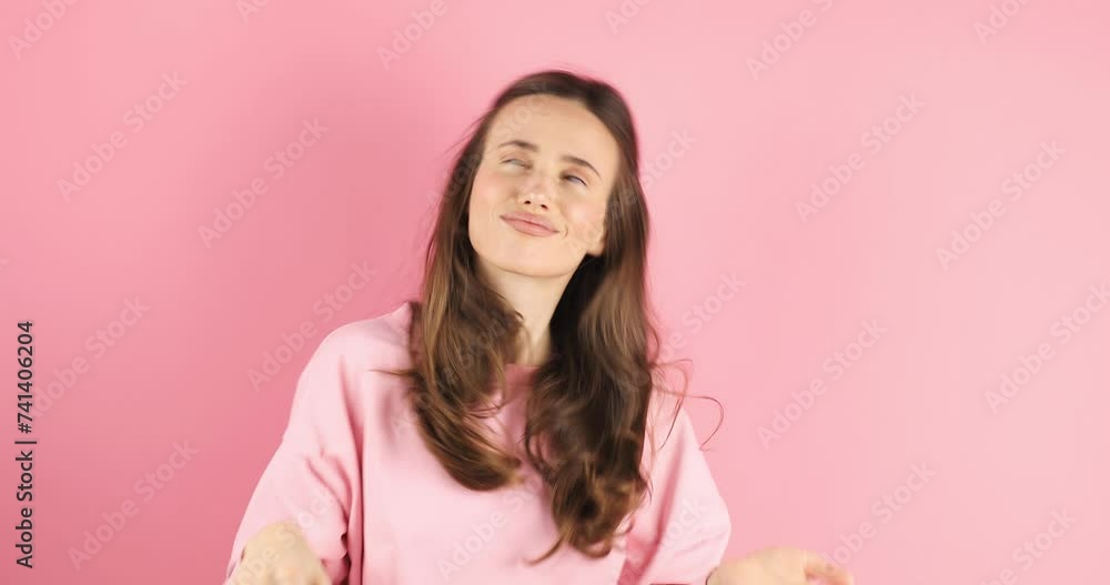 Young pathos woman pointing cheerfully while giving her imaginary money, in front of a pink background. The concept of pouring money without thinking. It makes it rain by throwing money into the air. Young pathos woman pointing cheerfully while giving her imaginary money, in front of a pink background. The concept of pouring money without thinking. It makes it rain by throwing money into the air.