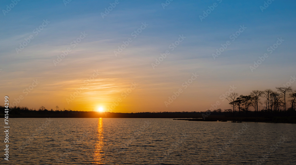 Sunrise at coast of the lake. Nature landscape during sunset sky background.