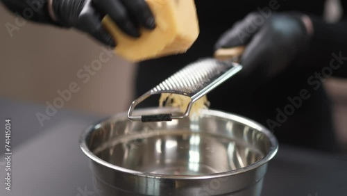 Grating cheese close-up. Food preparation and recipes concept. photo