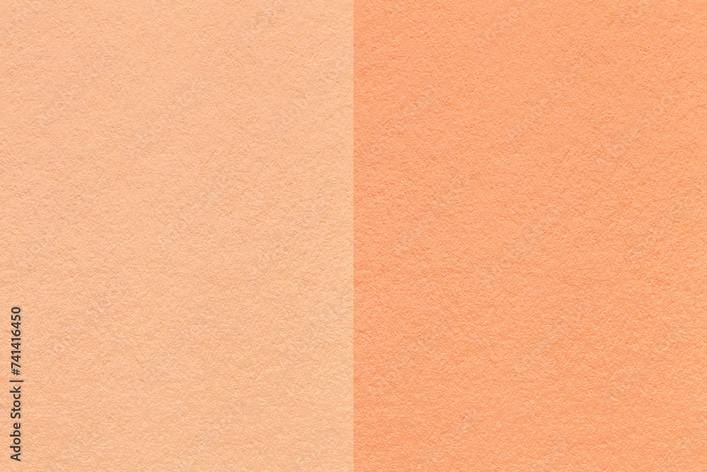 Color of the year 2024. Texture of craft peach fuzz and coral paper background, half two colors, macro. Color of the year 2024. Texture of craft peach fuzz and coral paper background, half two colors, macro.